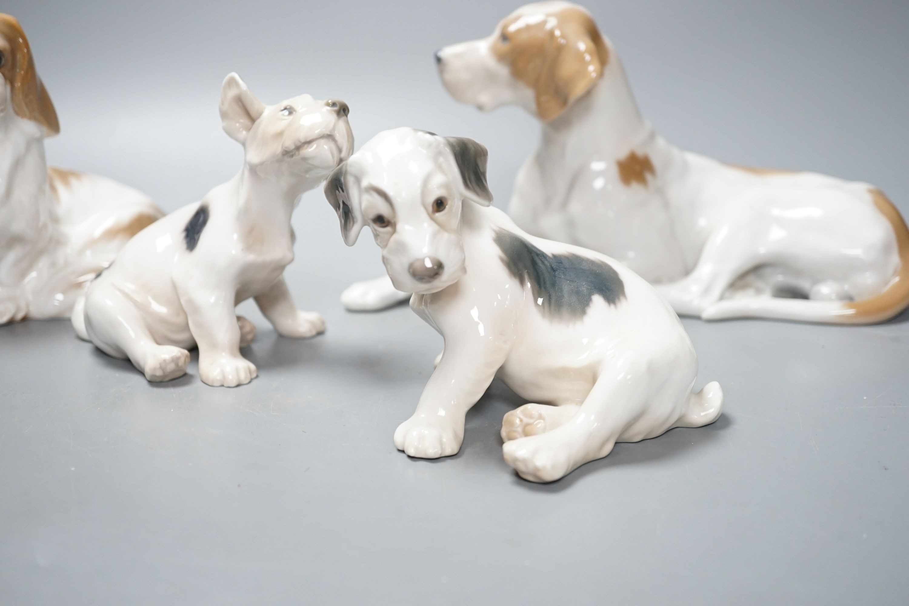 Two Royal Copenhagen figures of dogs and two Bing and Grondahl figures of dogs, largest 23 cms wide